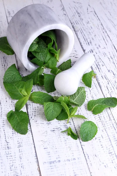 Menta verde fresca en mortero sobre fondo de madera de color — Foto de Stock