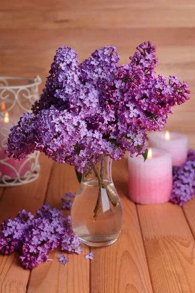 Lindas flores lilás em vaso na mesa sobre fundo de madeira — Fotografia de Stock