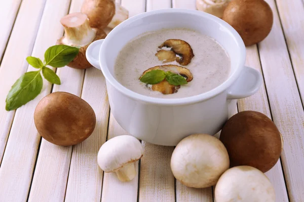 Mushroom soup in white pot on wooden background — Stock Photo, Image