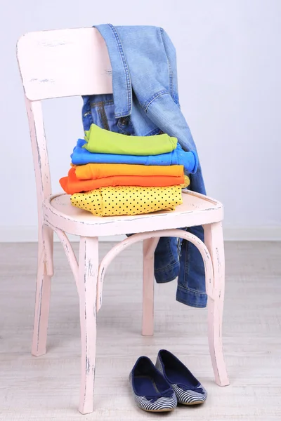 Ropa en silla sobre fondo gris —  Fotos de Stock