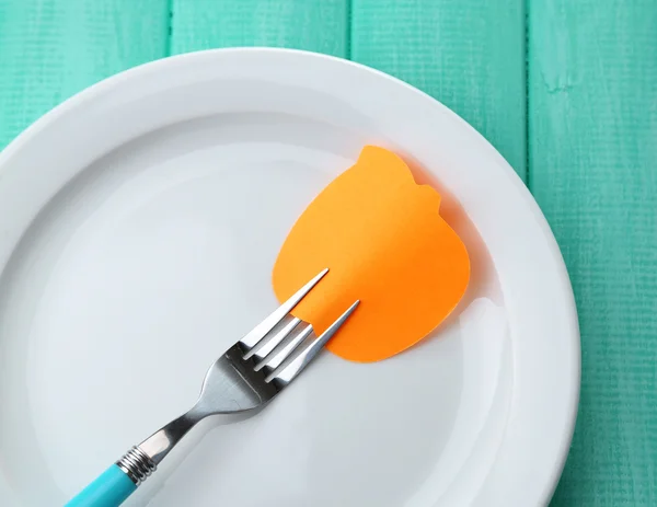 Empty note paper attached to fork, on plate, on color wooden background — Stock Photo, Image