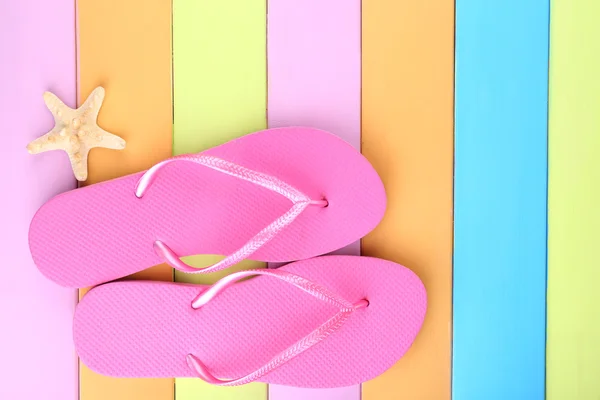 Bright flip-flops on color wooden background — Stock Photo, Image