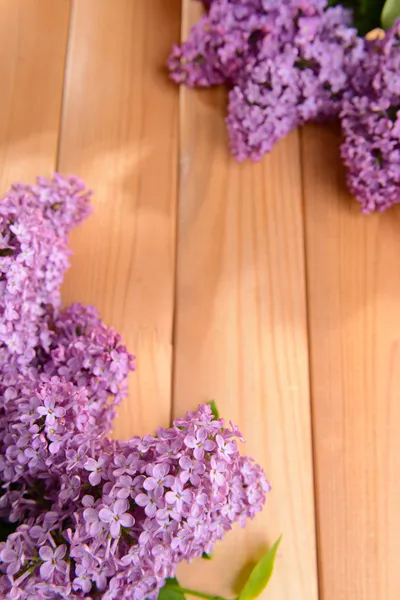 Beautiful lilac flowers on wooden background — Stock Photo, Image