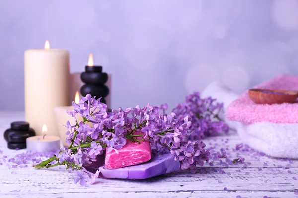 Composição com tratamento de spa, toalhas e flores lilás — Fotografia de Stock