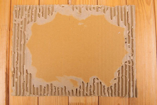 Картон на деревянном фоне — стоковое фото