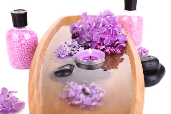 Composição com tratamento de spa, tigela de madeira com água, toalha e flores lilás, isolado em branco — Fotografia de Stock