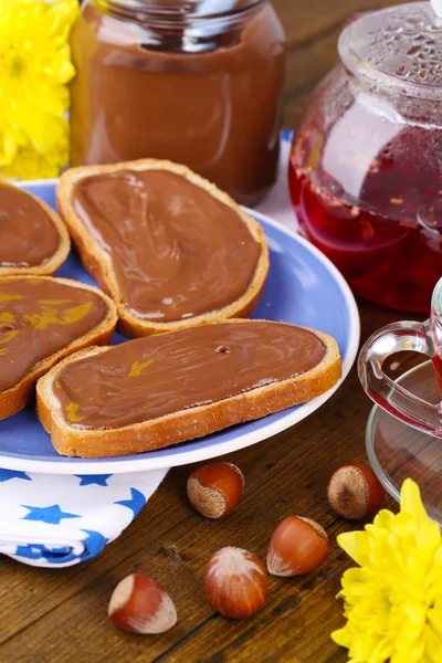 Ψωμί με γλυκό φουντούκι σοκολάτας απλωμένο σε πιάτο στο τραπέζι — Φωτογραφία Αρχείου