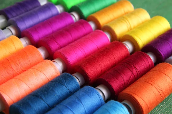 Multicolor sewing threads on wooden background — Stock Photo, Image