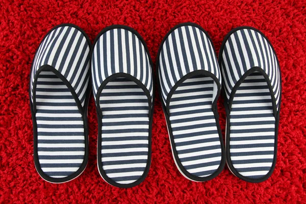 Pantofole a strisce su sfondo tappeto — Foto Stock