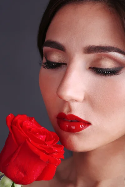 Girl with red lips and rose on dark background — Stock Photo, Image