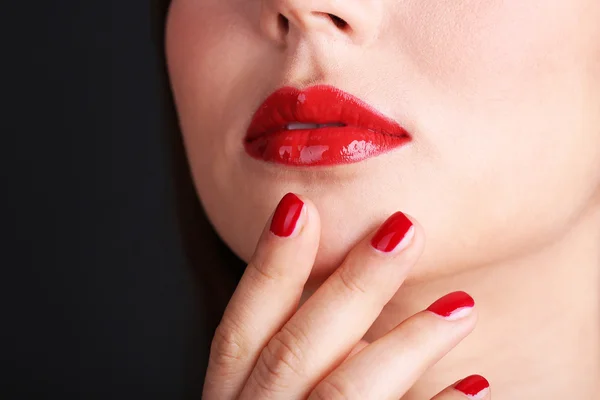 Menina com lábios vermelhos e unhas no fundo escuro — Fotografia de Stock