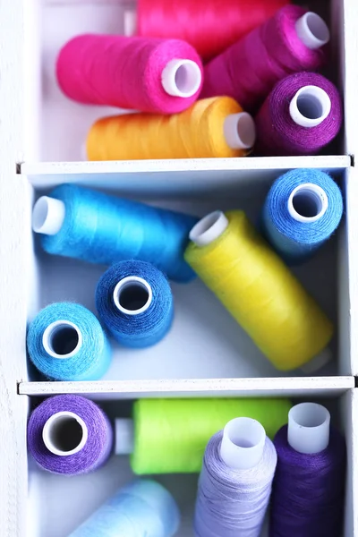 Hilo de coser multicolor en caja de madera, primer plano —  Fotos de Stock