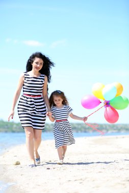 mutlu anne ve kızı. Sahilde yürüyüş