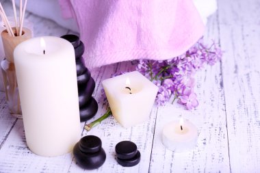 ışık arka plan üzerinde spa tedavisi, havlu ve eflatun çiçekler ile kompozisyon