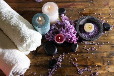 ahşap zemin üzerinde spa tedavisi, havlu ve eflatun çiçekler ile kompozisyon
