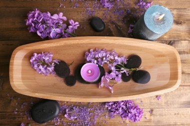 ahşap zemin üzerine su ve eflatun çiçekli ahşap kase ile kompozisyon