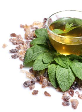 kompozisyon taze nane yaprakları, nane çayı cam bardak ve üzerinde beyaz izole kahverengi şeker