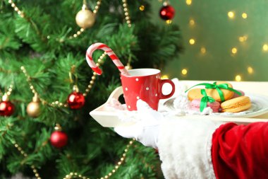 Kupa ve çerezler ile plaka elinde tutan santa