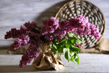 güzel Eflatun çiçekler vazoda renkli ahşap zemin üzerinde