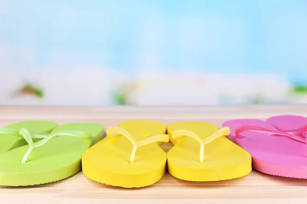 Tongs lumineuses sur table en bois, sur fond nature — Photo