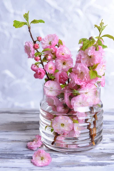 ผลไม้ที่สวยงาม ดอกไม้ในขวดบนโต๊ะบนพื้นหลังสีเทา — ภาพถ่ายสต็อก