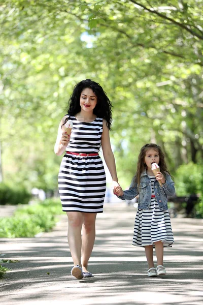 Feliz mamá y su hija. Caminar por el parque verde —  Fotos de Stock