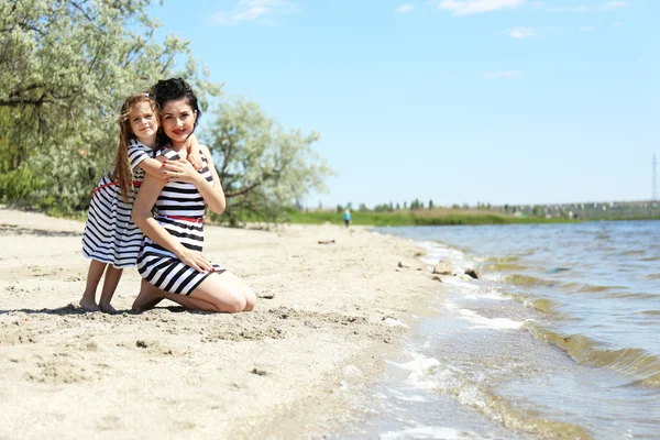 Happy mom and daughter on the beach — Stock Photo, Image