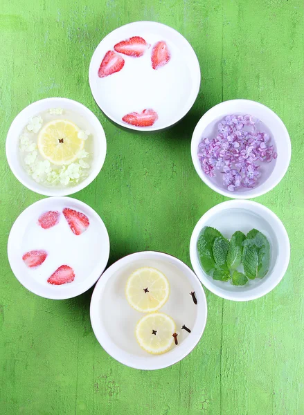 Aromatherapy treatment bowl with flowers and perfumed water on wooden background — Stock Photo, Image