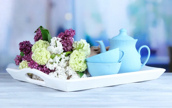 Composition avec ensemble de thé et bouquet de belles fleurs printanières sur plateau, sur table en bois, sur fond lumineux — Photo