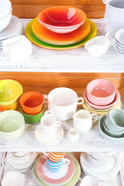 Different tableware on shelf, on wooden background — Stock Photo, Image