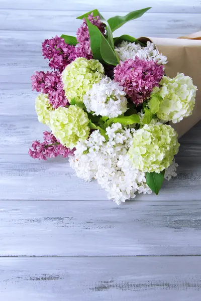 Beautiful bouquet of spring flowers on color wooden background — Stock Photo, Image
