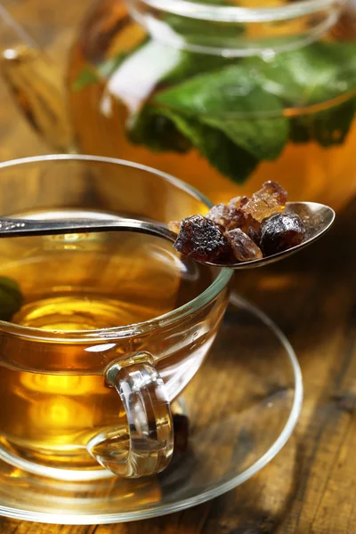 Composition of fresh mint tea in glass cup and teapot  on wooden background — Stock Photo, Image