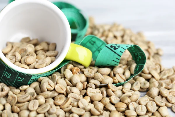 生コーヒー豆と木の色の背景上の測定テープ。減量の概念 — ストック写真