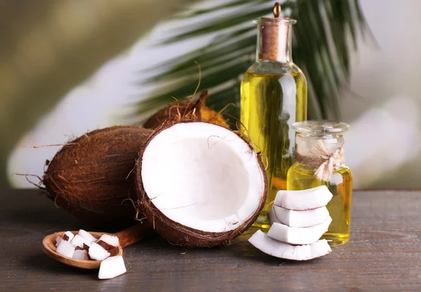 Coconuts and coconut oil on wooden table — Stock Photo, Image