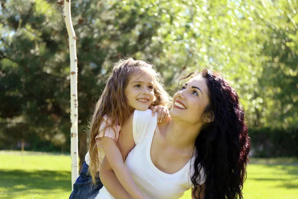 Feliz mamá y su hija. Caminar por el parque verde — Foto de Stock