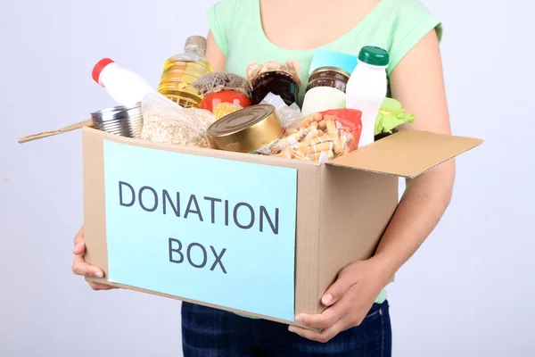 Волонтёр с коробкой для пожертвований с продуктами питания — стоковое фото