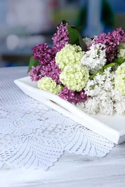 Composição com conjunto de chá e buquê de belas flores da primavera na bandeja, na mesa de madeira, no fundo brilhante — Fotografia de Stock