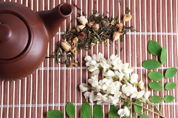 Herbal natural floral tea infusion with dry flowers ingredients, on bamboo mat background — Stock Photo, Image