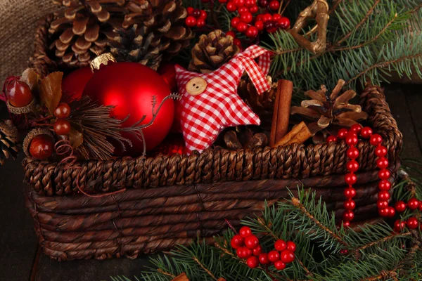 Vánoční ozdoby v košíku a smrkové větve na stole zblízka — Stock fotografie