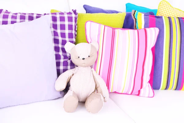 Медвежья игрушка с подушками на диване — стоковое фото