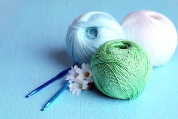 Colorful clews and crochet hooks on wooden background — Stock Photo, Image