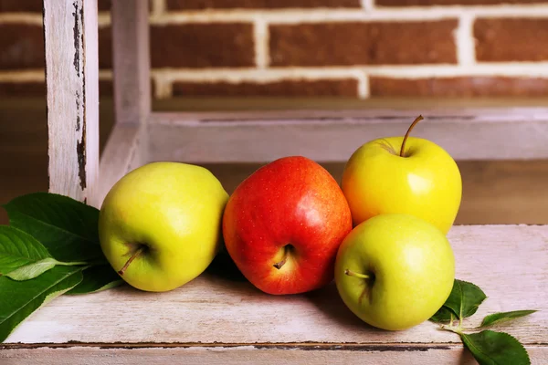 美丽的静物，成熟的甜苹果与上砖的背景墙上的叶子 — 图库照片