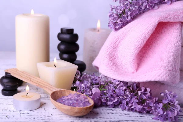 Composition with spa treatment, towels and lilac flowers, on light background — Stock Photo, Image