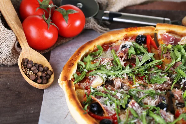 Pizza met rucola op een houten achtergrond kleur — Stockfoto