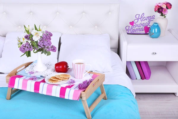 Light breakfast and beautiful bouquet on bed — Stock Photo, Image