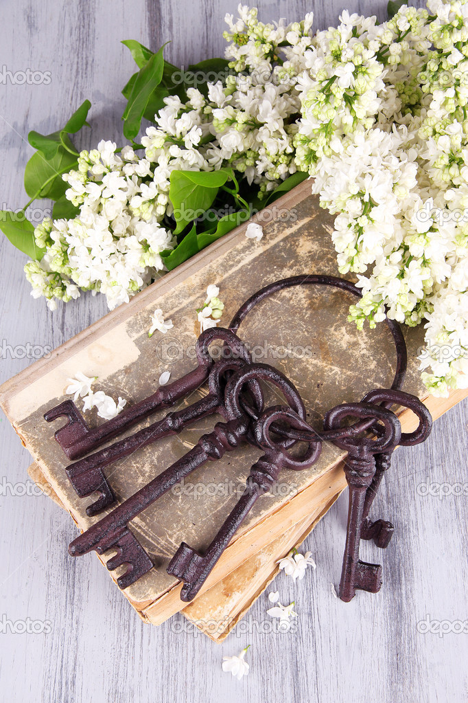 Beautiful composition with old keys and old books on wooden background