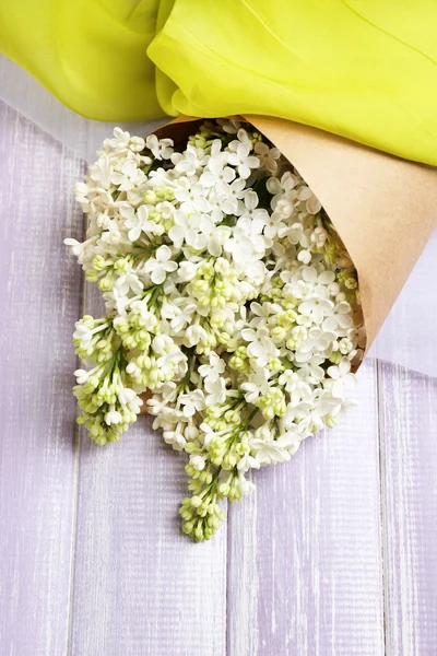 Beautiful lilac flowers on wooden table — Stock Photo, Image