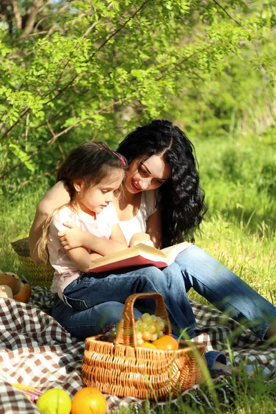 Feliz mamá y su hija. Picnic en el parque verde — Foto de Stock