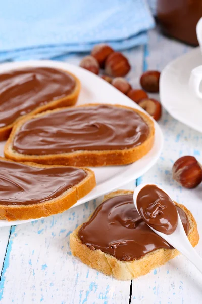 Bread with sweet chocolate hazelnut spread on plate on table — Stock Photo, Image