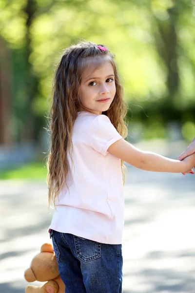 Счастливая маленькая девочка в зеленом парке — стоковое фото